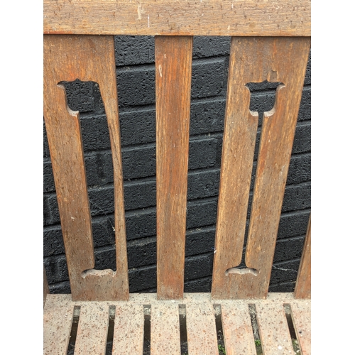 8 - A large Arts & Crafts style teak garden bench. 183x108cm