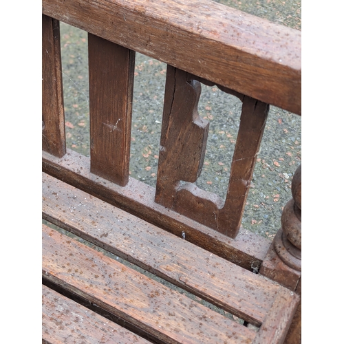 8 - A large Arts & Crafts style teak garden bench. 183x108cm