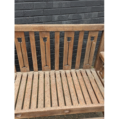 8 - A large Arts & Crafts style teak garden bench. 183x108cm