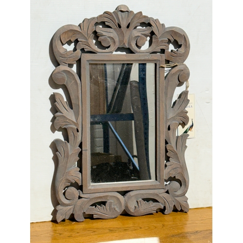 249 - An ornate wooden framed mirror. 40x60cm.