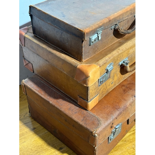 259 - Three vintage leather travelling cases. Largest 67x40x21cm.