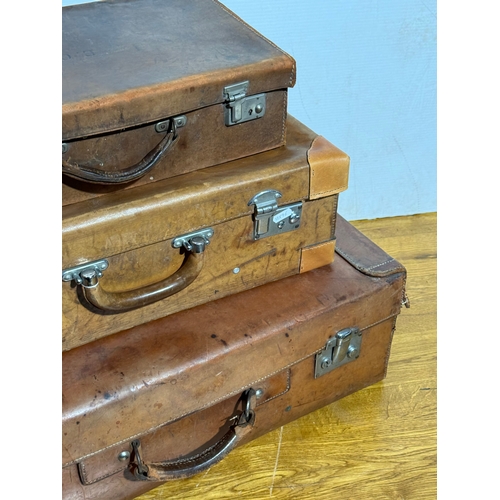 259 - Three vintage leather travelling cases. Largest 67x40x21cm.