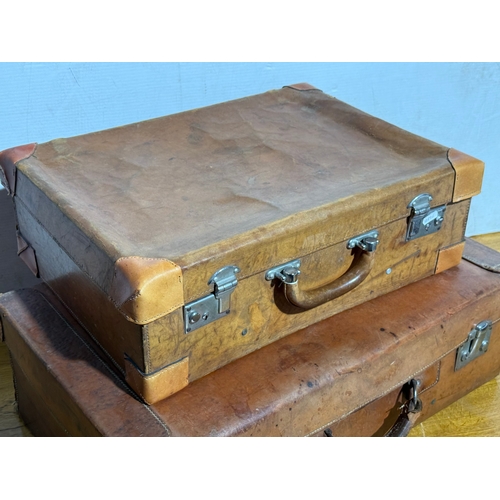 259 - Three vintage leather travelling cases. Largest 67x40x21cm.
