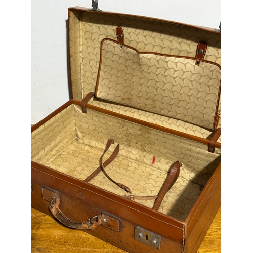 259 - Three vintage leather travelling cases. Largest 67x40x21cm.