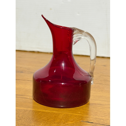 66 - A Whitefriars ruby glass jug. Designed by Geoffrey Baxter. 9x13cm.