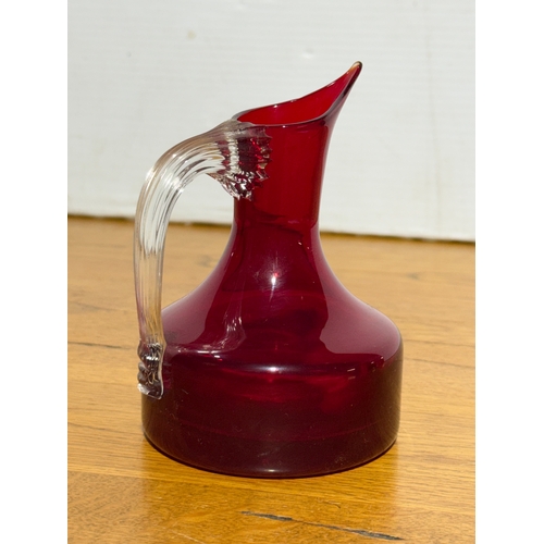 66 - A Whitefriars ruby glass jug. Designed by Geoffrey Baxter. 9x13cm.