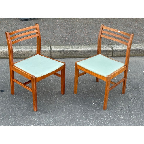393 - A pair of teak dining chairs.