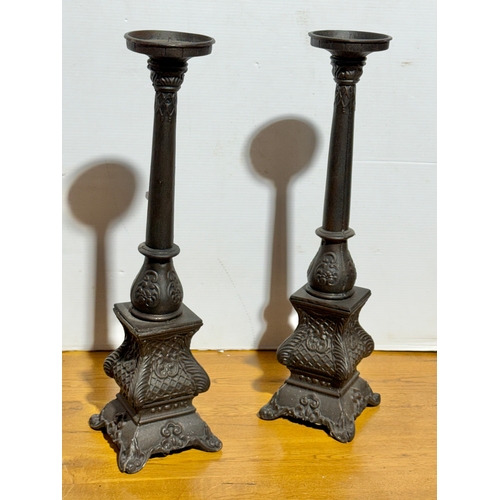249 - A pair of large cast iron candleholders. 59cm.