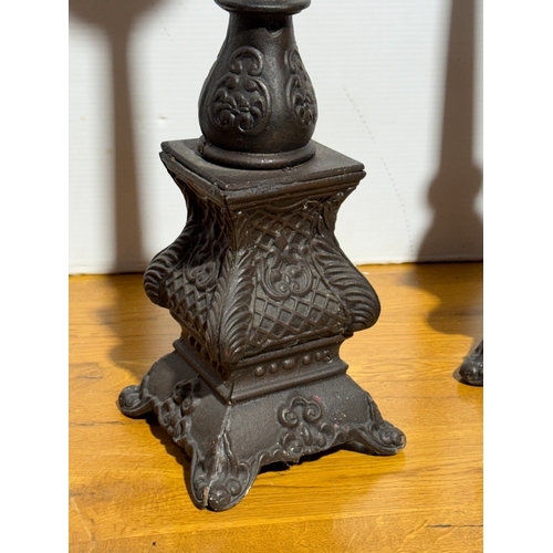 249 - A pair of large cast iron candleholders. 59cm.