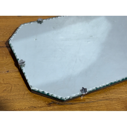 359 - An Art Deco bevelled mirror. 50x27cm