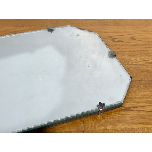 359 - An Art Deco bevelled mirror. 50x27cm