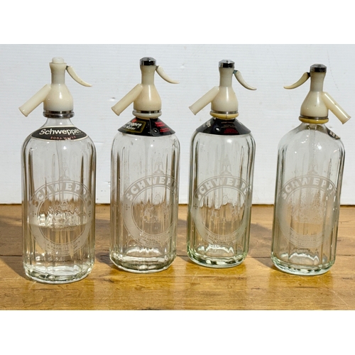 251 - Four vintage Schweppes soda syphons. 30cm.