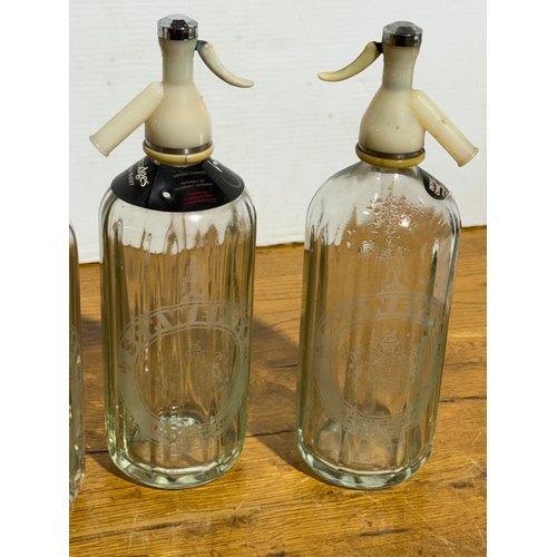 251 - Four vintage Schweppes soda syphons. 30cm.