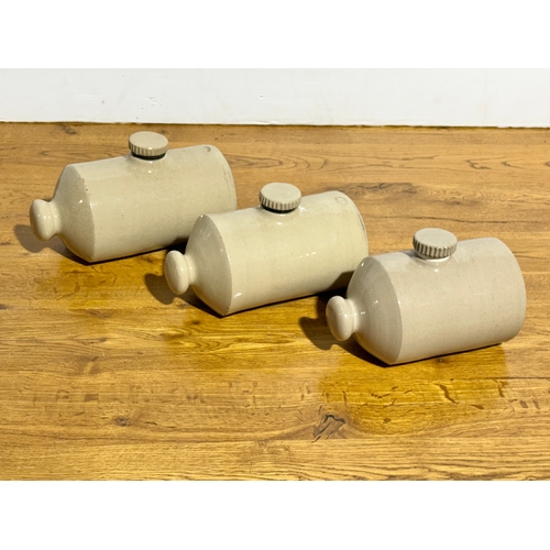 405 - Three vintage stone hot water bottles.