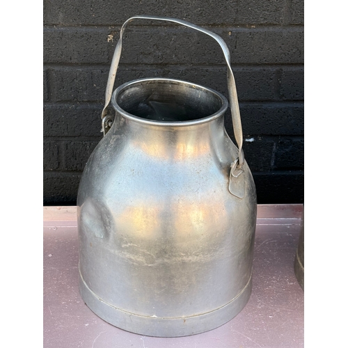 363 - A pair of vintage stainless steel milk churns.