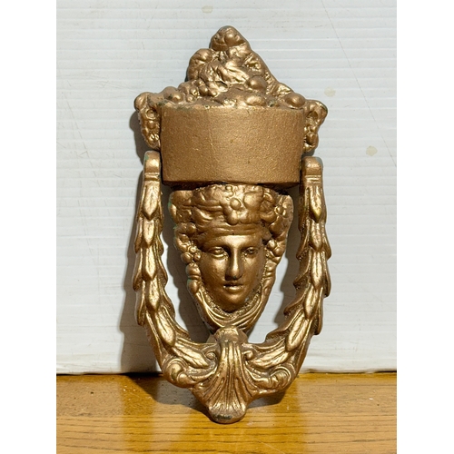 369 - An early 20th century Regency style cast iron door knocker. 10x20cm.