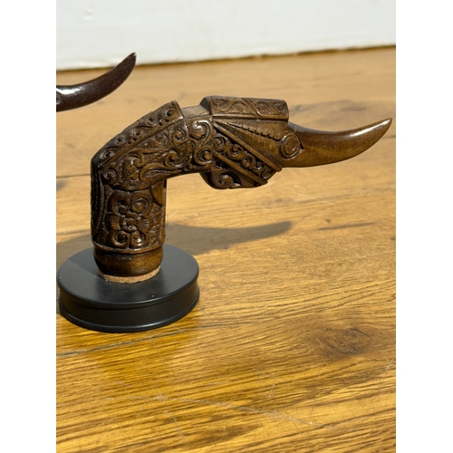388 - A pair of keris hilt coat hooks. 15cm.