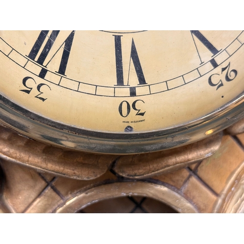 218 - A German Giltwood Rococo Style Wall Clock. Early 20th Century. 30x55cm.