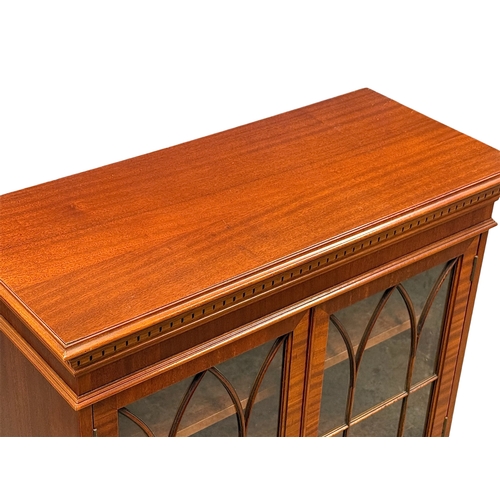 239 - A Georgian Style Mahogany Bookcase. Dentil cornice over two astragal glazed doors and adjustable she... 