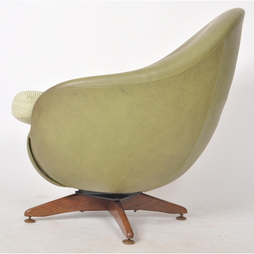 15 - A retro mid 20th Century faux green leather upholstered swivel egg chair / easy lounge armchair havi... 
