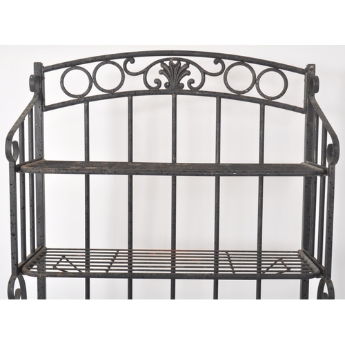 17 - A contemporary French style bakers rack having a wrought iron frame finished in black with paneled o... 