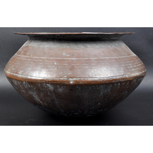 7 - An 18th Century Indonesian copper serving pot of bulbous circular form having a flat circular rim ov... 