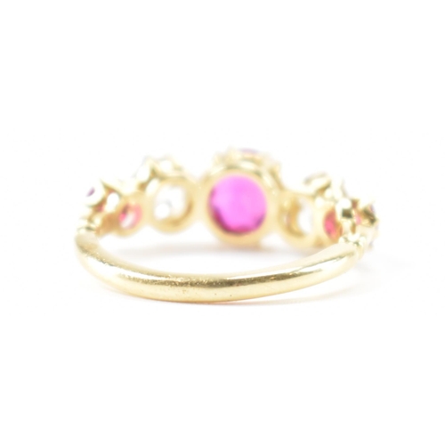 202 - A gold ruby and diamond five stone ring.  The ring set with a central round cut ruby flanked by two ... 