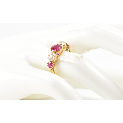 202 - A gold ruby and diamond five stone ring.  The ring set with a central round cut ruby flanked by two ... 