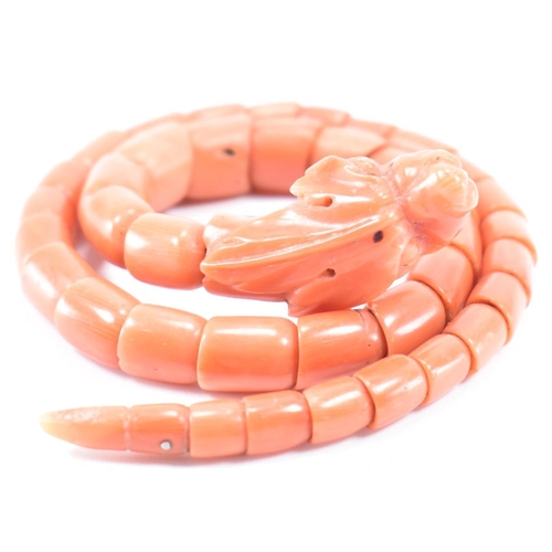 204 - A 19th century coral serpent bangle. The serpent / snake bangle formed of carved overlocking coral b... 