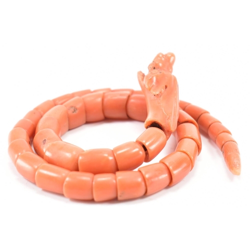 204 - A 19th century coral serpent bangle. The serpent / snake bangle formed of carved overlocking coral b... 