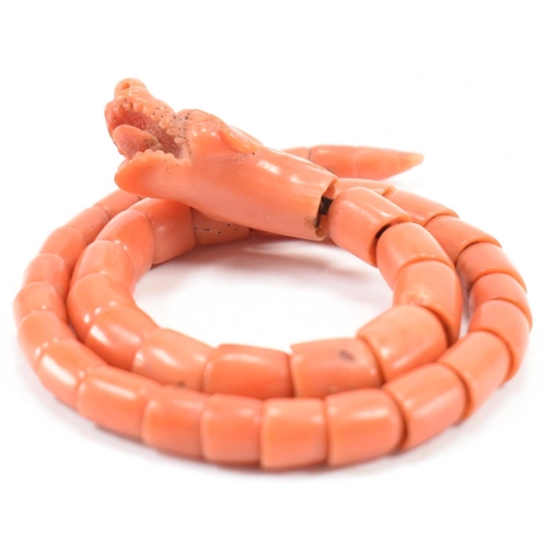 204 - A 19th century coral serpent bangle. The serpent / snake bangle formed of carved overlocking coral b... 