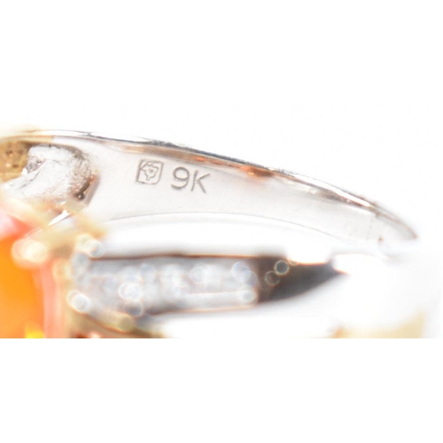 211 - A hallmarked 9ct gold fire opal. The ring being set with an oval cut fire opal to the centre within ... 