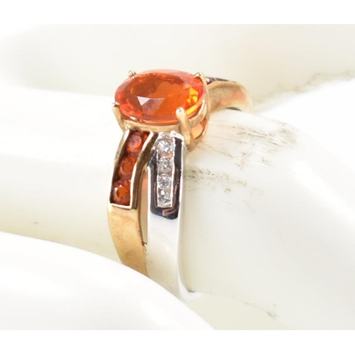 211 - A hallmarked 9ct gold fire opal. The ring being set with an oval cut fire opal to the centre within ... 