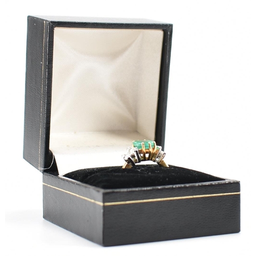 212 - A hallmarked 18ct gold synthetic emerald & diamond ring. The ring set with a central oval synthetic ... 