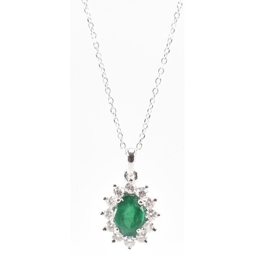 216 - A hallmarked 18ct gold emerald and diamond pendant necklace. The necklace having a fine link chain s... 