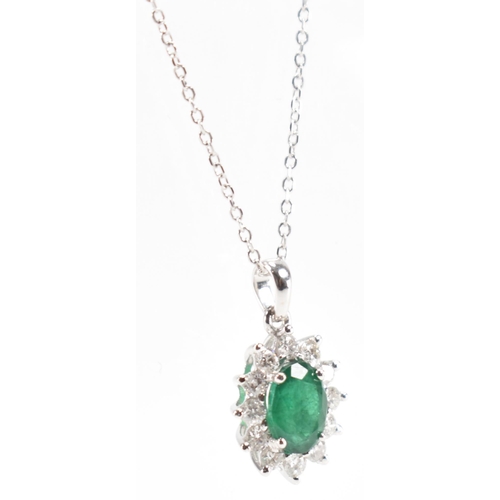 216 - A hallmarked 18ct gold emerald and diamond pendant necklace. The necklace having a fine link chain s... 