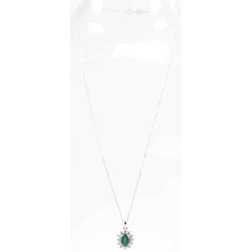 216 - A hallmarked 18ct gold emerald and diamond pendant necklace. The necklace having a fine link chain s... 