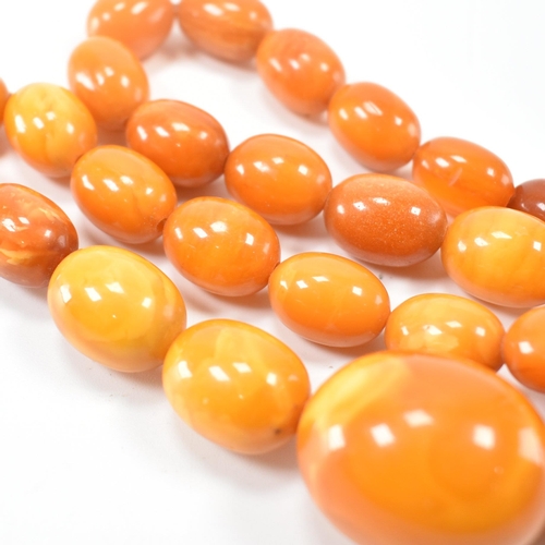 225 - A vintage butterscotch amber beaded necklace. The necklace having twenty seven oval beads. Largest c... 