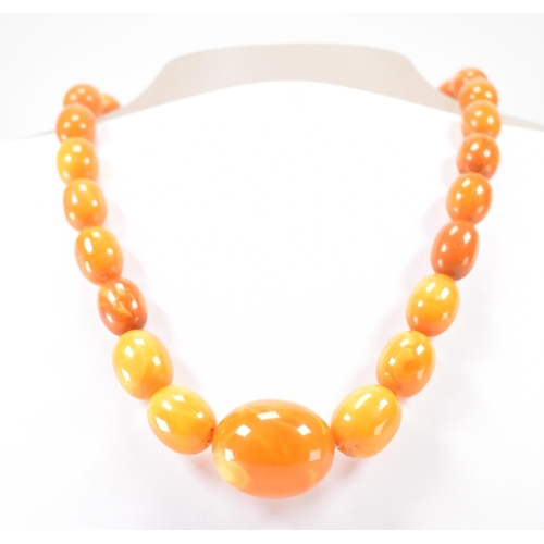 225 - A vintage butterscotch amber beaded necklace. The necklace having twenty seven oval beads. Largest c... 