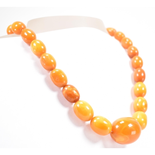 225 - A vintage butterscotch amber beaded necklace. The necklace having twenty seven oval beads. Largest c... 