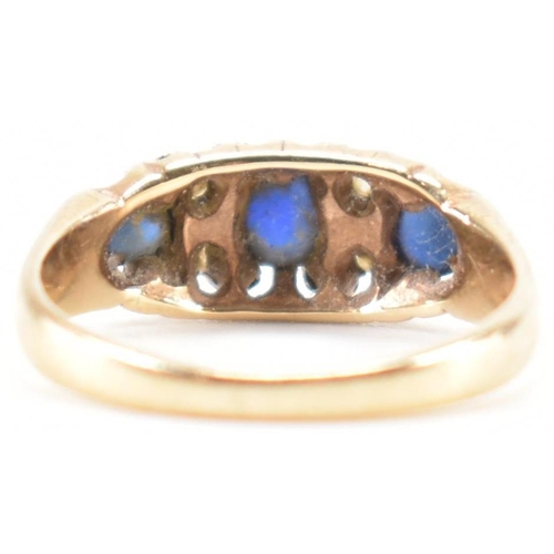 228 - A vintage gold blue and white stone ring. The ring being set with three round cut blue stones and wh... 