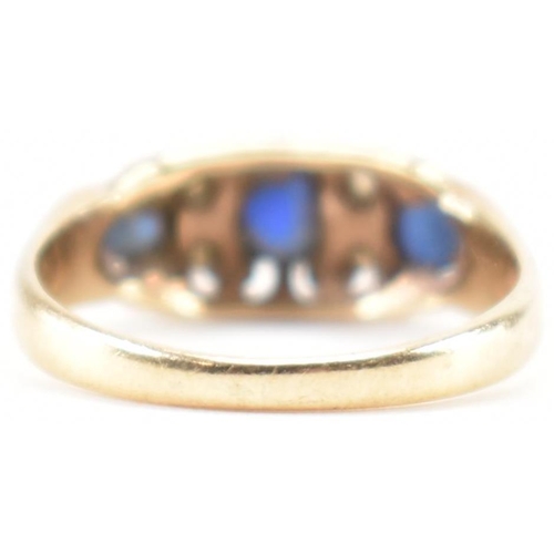 228 - A vintage gold blue and white stone ring. The ring being set with three round cut blue stones and wh... 