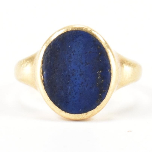 233 - A hallmarked 18ct gold signet ring having oval lapis lazuli panel to centre set within a bezel mount... 