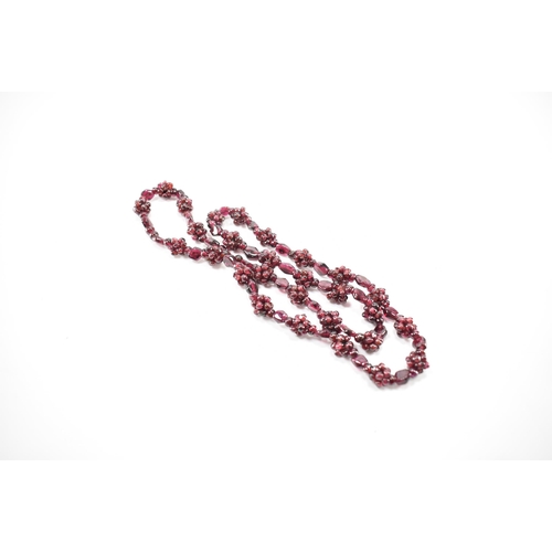 244 - A vintage garnet beaded necklace. The necklace threaded with clusters of garnet beads. Measures 24 i... 