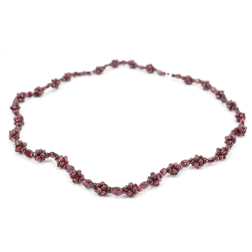 244 - A vintage garnet beaded necklace. The necklace threaded with clusters of garnet beads. Measures 24 i... 