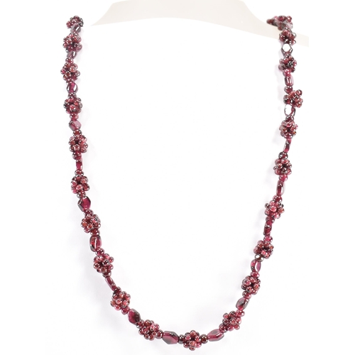 244 - A vintage garnet beaded necklace. The necklace threaded with clusters of garnet beads. Measures 24 i... 