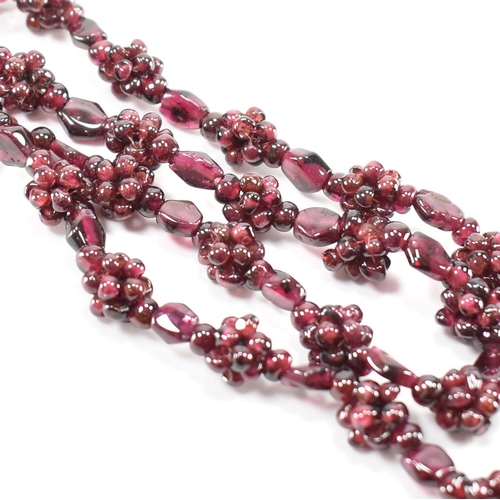 244 - A vintage garnet beaded necklace. The necklace threaded with clusters of garnet beads. Measures 24 i... 