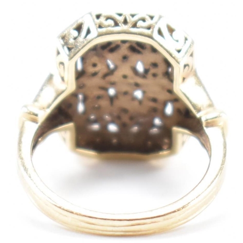 248 - A vintage gold and diamond panel ring. The ring having a canted rectangular panel to the head set th... 