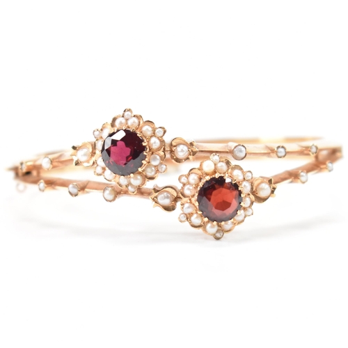 287 - An 18ct gold garnet and pearl bangle. The bracelet having twin knife bar mount with 2 garnet and pea... 