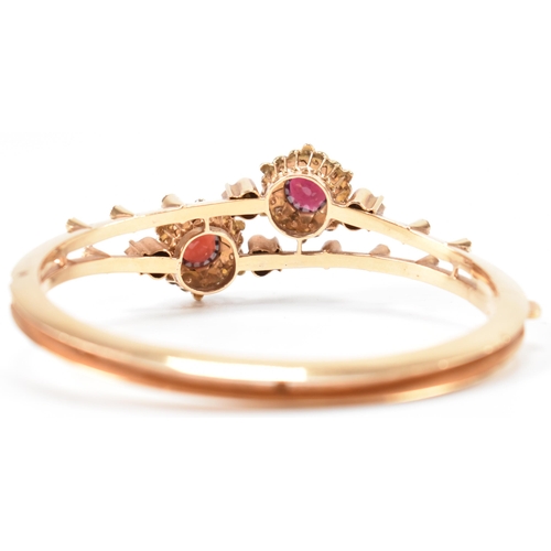 287 - An 18ct gold garnet and pearl bangle. The bracelet having twin knife bar mount with 2 garnet and pea... 